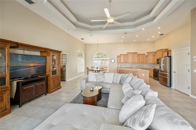 living area with light tile patterned flooring, crown molding, and a raised ceiling