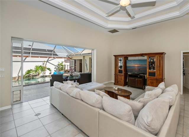 living area with visible vents, ornamental molding, a sunroom, light tile patterned floors, and a raised ceiling