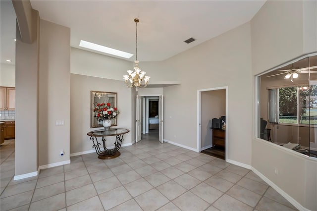 unfurnished dining area featuring light tile patterned floors, visible vents, baseboards, and high vaulted ceiling