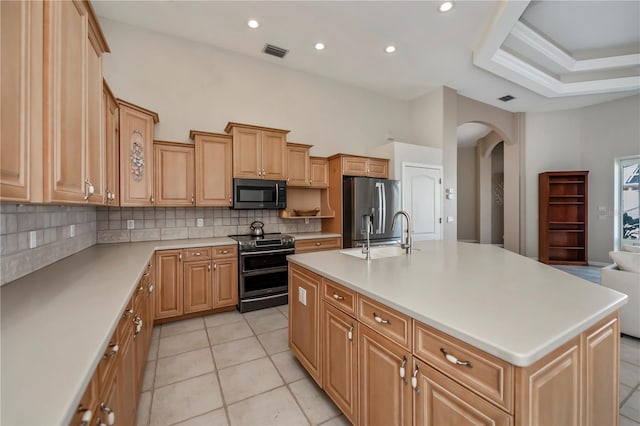 kitchen with visible vents, a sink, backsplash, stainless steel appliances, and arched walkways