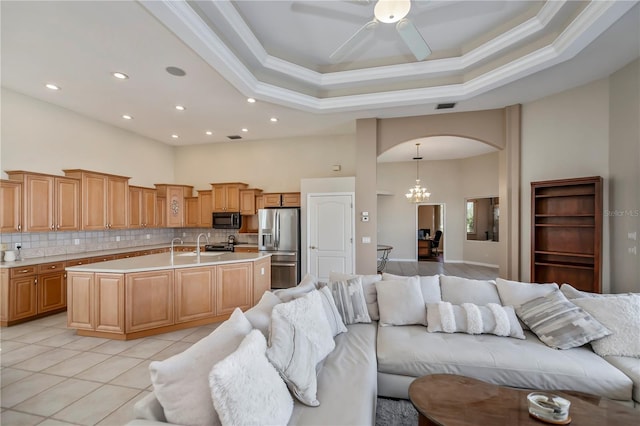 kitchen featuring visible vents, stainless steel refrigerator with ice dispenser, open floor plan, arched walkways, and black microwave