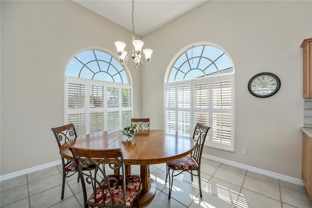 dining space featuring high vaulted ceiling, light tile patterned floors, baseboards, and a chandelier