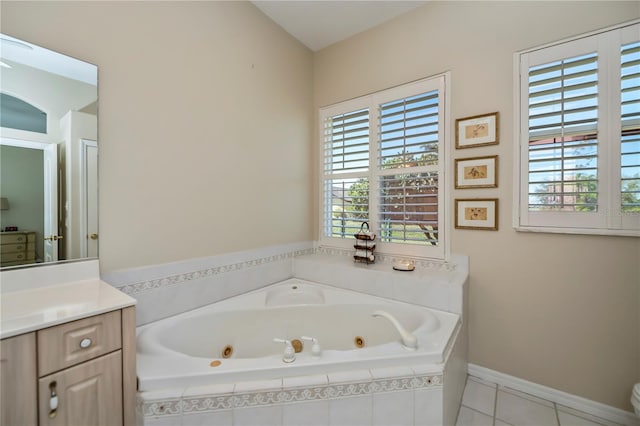 bathroom featuring a wealth of natural light, vanity, a whirlpool tub, and tile patterned flooring