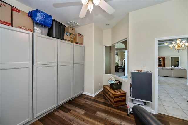 interior space featuring baseboards, wood finished floors, and ceiling fan with notable chandelier