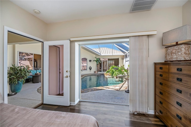 doorway to outside with a skylight, visible vents, baseboards, and wood finished floors