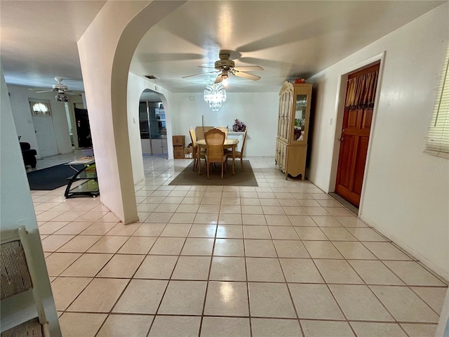 dining area featuring ceiling fan, visible vents, arched walkways, and light tile patterned flooring