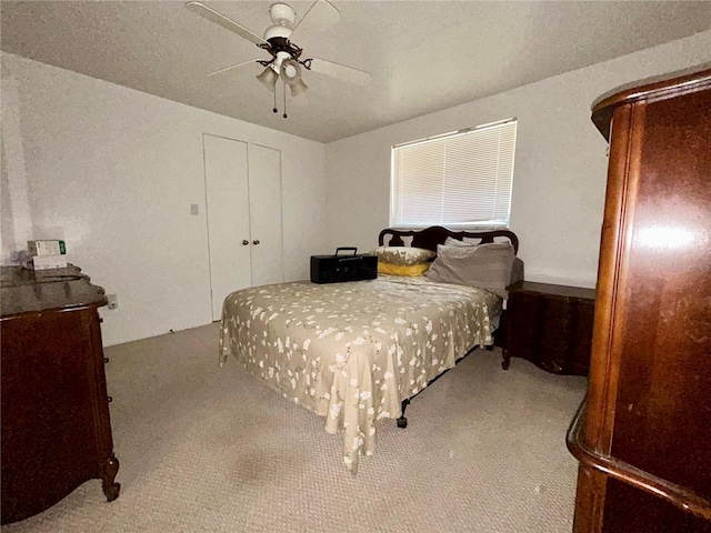 bedroom with carpet floors, a ceiling fan, and a closet