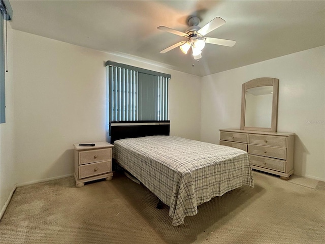 bedroom featuring light colored carpet, ceiling fan, and baseboards