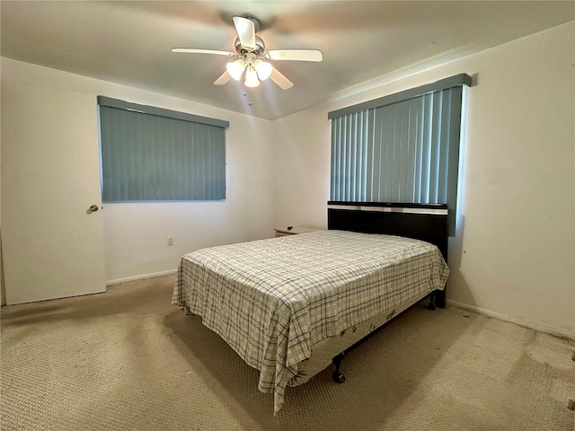 carpeted bedroom with a ceiling fan and baseboards