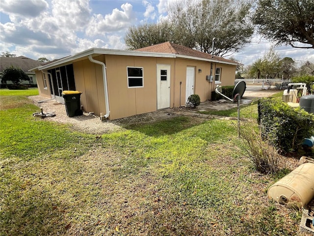 view of side of property with a lawn and fence