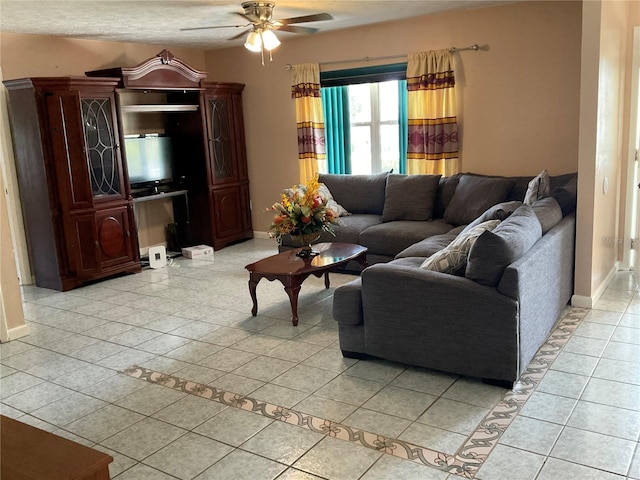 living room with light tile patterned flooring, a ceiling fan, and baseboards