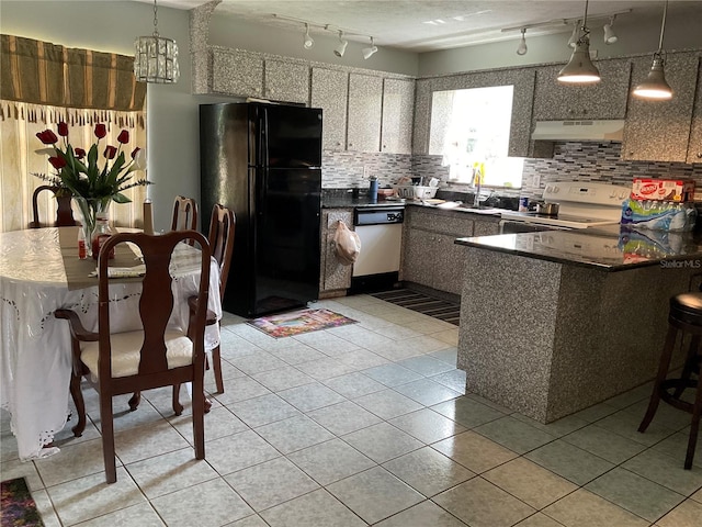 kitchen featuring decorative light fixtures, decorative backsplash, a peninsula, white appliances, and under cabinet range hood