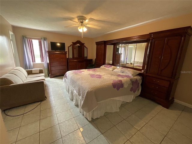 bedroom with light tile patterned floors, a ceiling fan, and baseboards