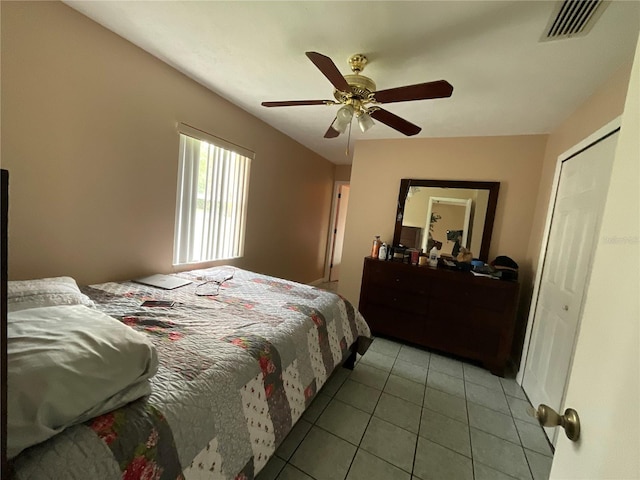 bedroom with light tile patterned floors, ceiling fan, and visible vents
