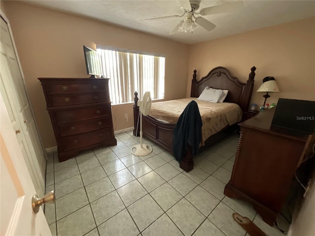 bedroom featuring a ceiling fan, baseboards, and light tile patterned floors