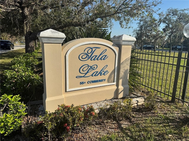 community sign featuring fence and a yard