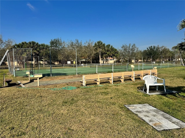 view of property's community with fence and a lawn