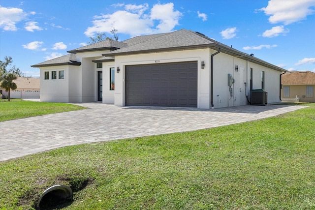 view of front facade featuring a garage, decorative driveway, a front lawn, and stucco siding