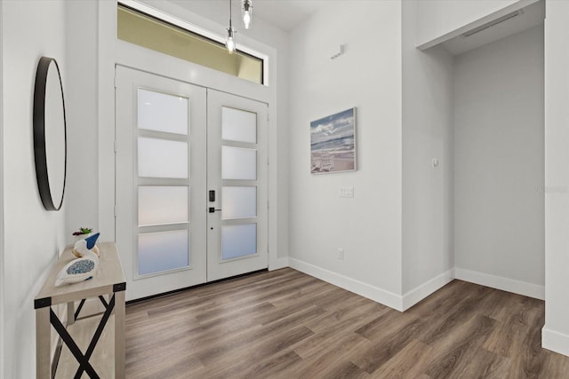 entryway with baseboards, visible vents, wood finished floors, and french doors