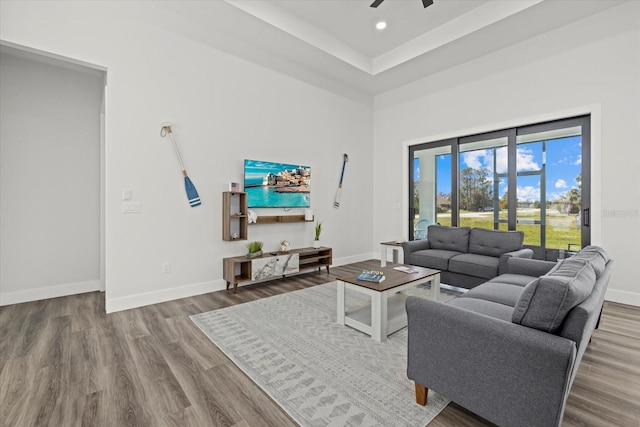 living room with a high ceiling, baseboards, wood finished floors, and recessed lighting