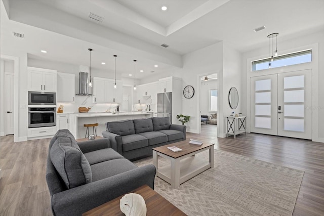 living room with french doors, recessed lighting, visible vents, light wood-style floors, and baseboards