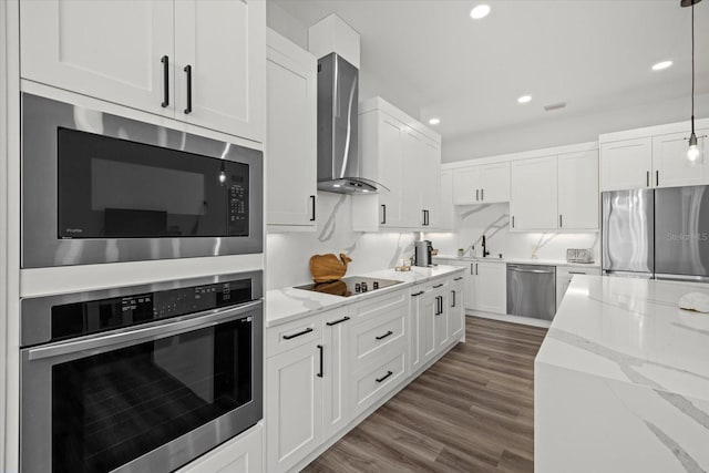 kitchen featuring wall chimney exhaust hood, appliances with stainless steel finishes, wood finished floors, and white cabinets