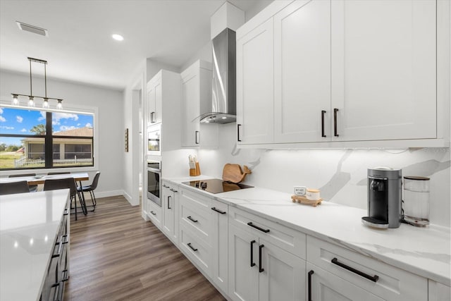 kitchen featuring black electric stovetop, visible vents, white cabinetry, wood finished floors, and wall chimney exhaust hood