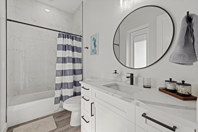 bathroom featuring wood finished floors, vanity, toilet, and shower / bathtub combination with curtain