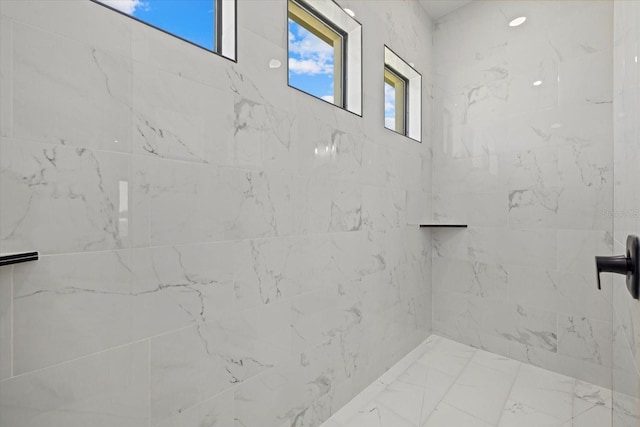 bathroom featuring marble finish floor and tiled shower