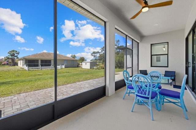 sunroom / solarium featuring a ceiling fan