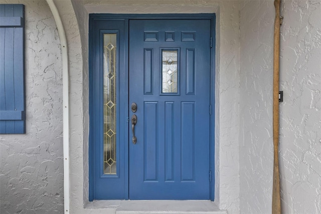 view of exterior entry featuring stucco siding