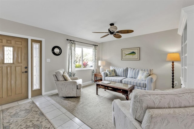 living area featuring light tile patterned floors, ceiling fan, and baseboards