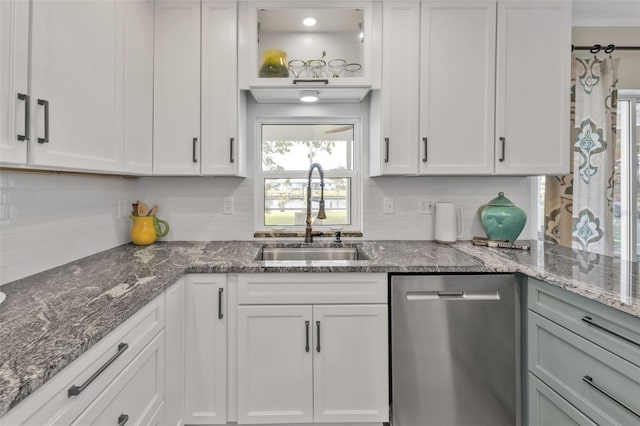 kitchen with a sink, white cabinetry, backsplash, and stainless steel dishwasher