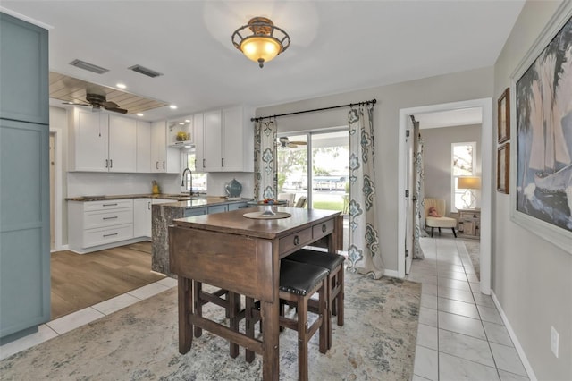 dining space with light tile patterned floors, ceiling fan, visible vents, and baseboards