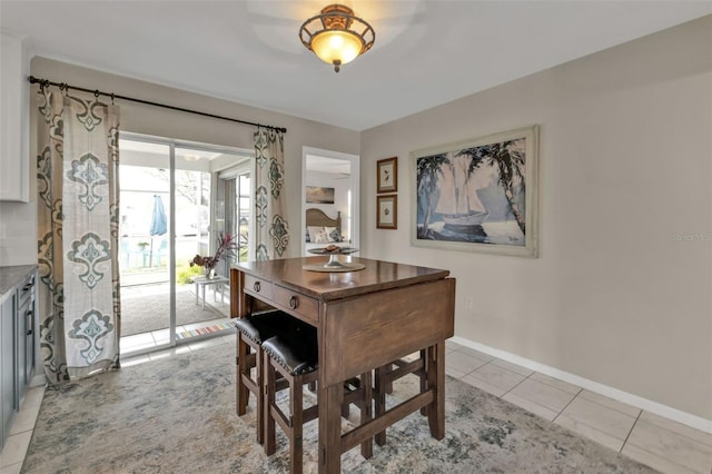 dining area with baseboards and light tile patterned floors