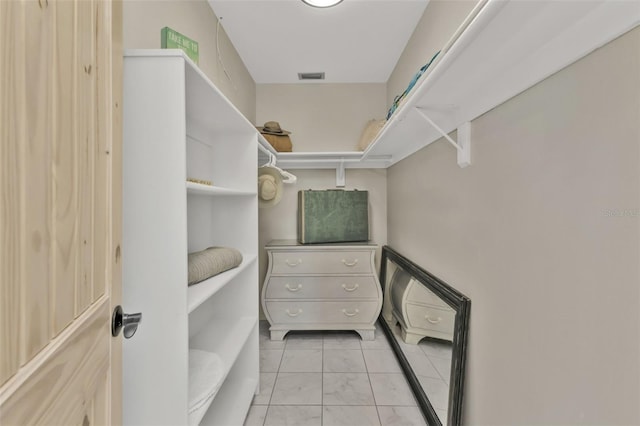 walk in closet with marble finish floor and visible vents