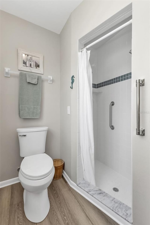 bathroom with a shower stall and wood finished floors