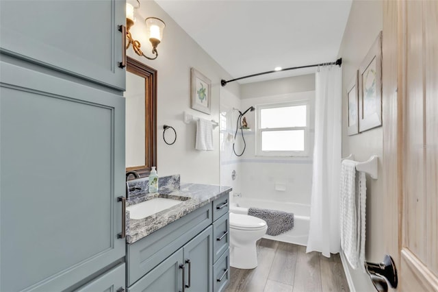 bathroom with vanity, wood finished floors, toilet, and shower / bathtub combination with curtain