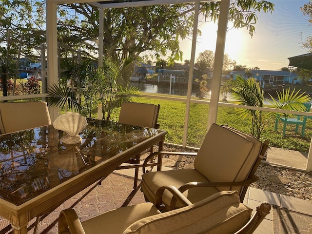 sunroom featuring a water view