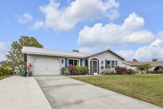 ranch-style house with concrete driveway, metal roof, an attached garage, a front yard, and stucco siding