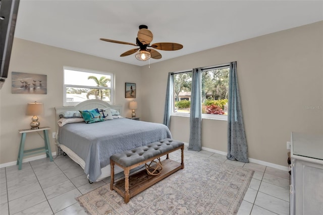 bedroom with ceiling fan, multiple windows, light tile patterned flooring, and baseboards