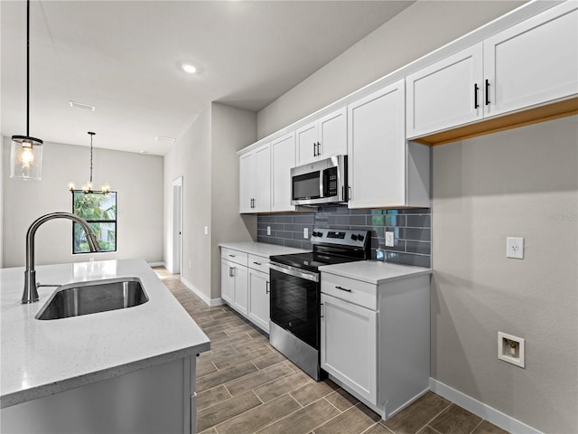 kitchen featuring appliances with stainless steel finishes, white cabinets, a sink, and tasteful backsplash