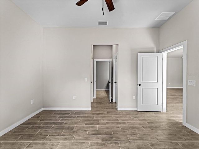 unfurnished bedroom featuring wood tiled floor, visible vents, ceiling fan, and baseboards