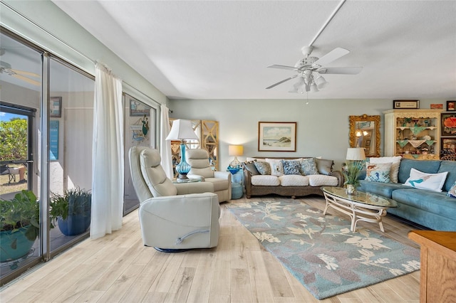 living area with a ceiling fan and wood finished floors