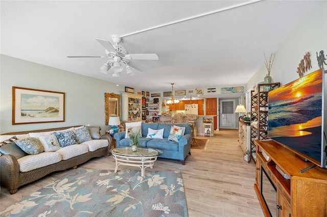 living area with a ceiling fan and light wood finished floors