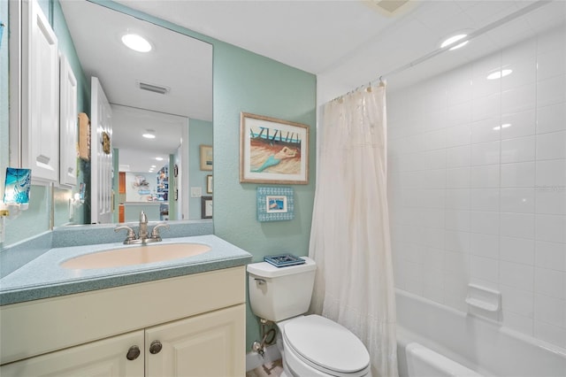 full bathroom featuring vanity, toilet, visible vents, and shower / tub combo with curtain