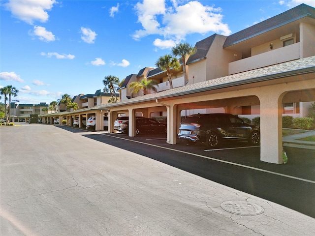 covered parking lot featuring a residential view