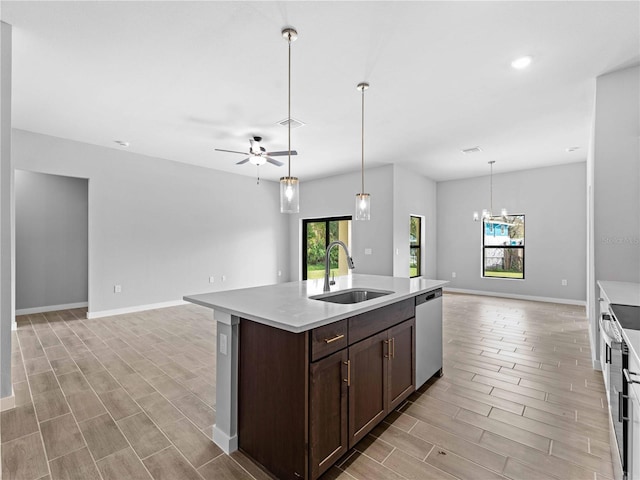 kitchen with open floor plan, dark brown cabinets, appliances with stainless steel finishes, and a sink