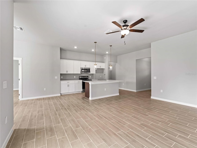 kitchen with ceiling fan, visible vents, stainless steel appliances, and open floor plan