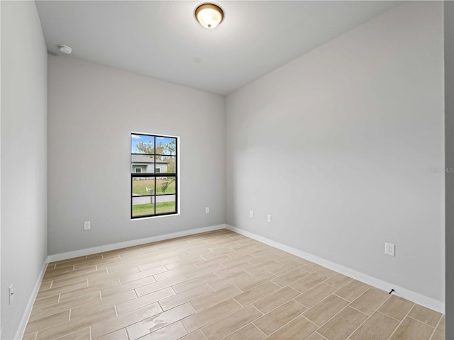 spare room featuring baseboards and wood finish floors